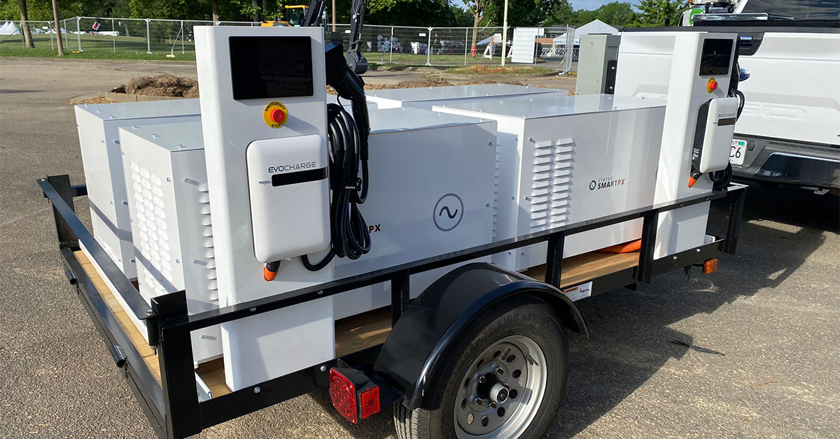 Mobile EV charging trailer featuring Evocharge station and SmartPX power system. Compact, trailer-mounted solution for on-site electric vehicle charging and mobile power distribution. White equipment on black trailer frame, showcasing portable clean energy technology for fleet and worksite applications.